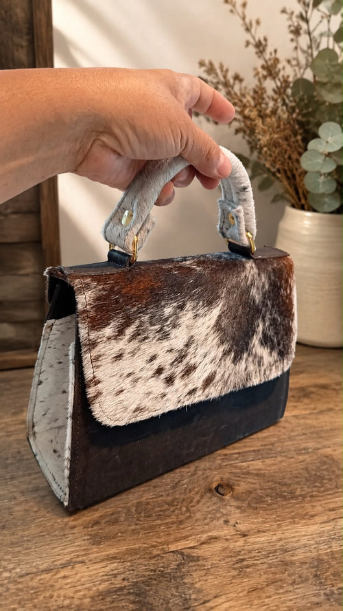 Black leather handbag with a soft fur finish/ Bolso de piel negra con pelo suave